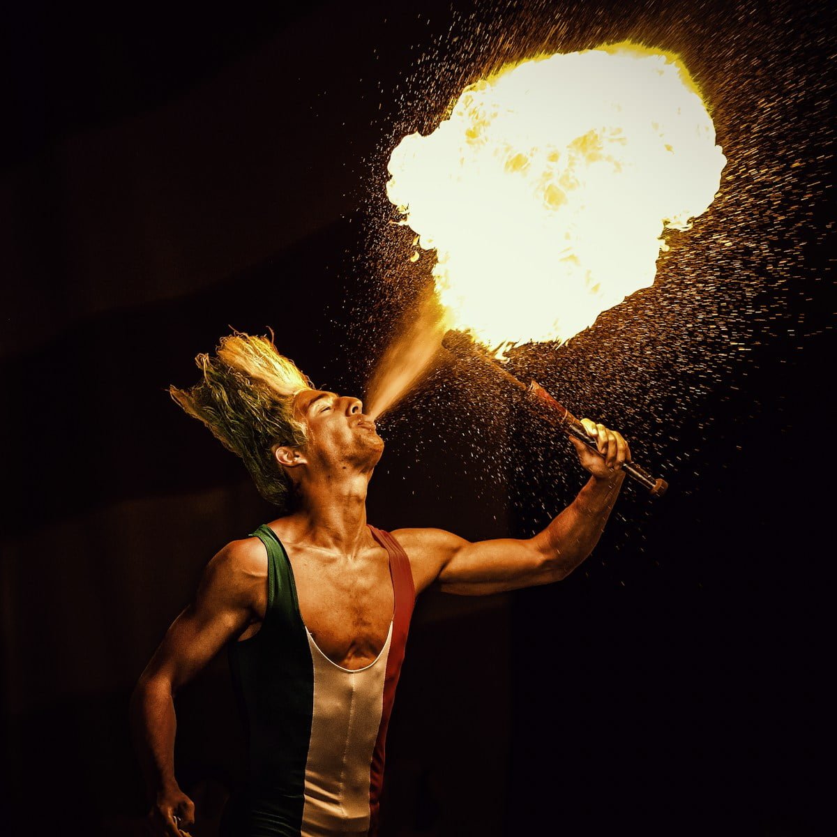 man blowing gas on tourch